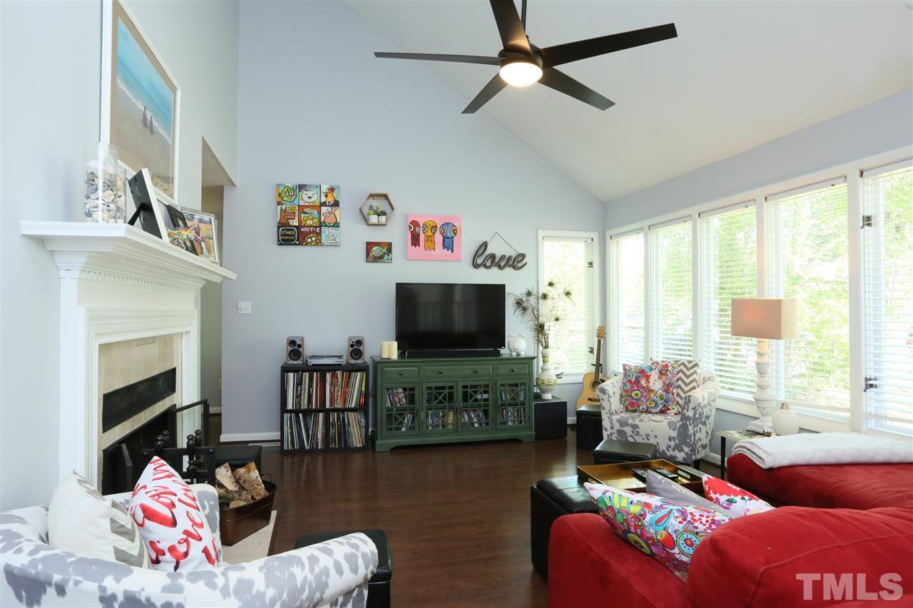 321 Bentpine Drive Raleigh, NC 27603 - Photo 6 of 30 a living room with furniture a flat screen tv and a floor to ceiling window