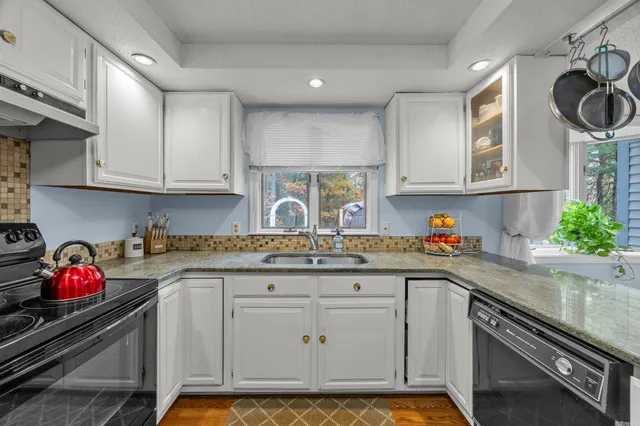 a kitchen with stainless steel appliances granite countertop a sink stove and cabinets