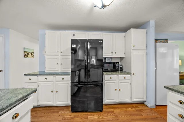 a kitchen that has a lot of cabinets in it and wooden floors