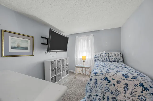 a bedroom with a large bed and a chandelier