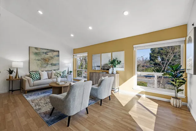 a living room with fireplace furniture and a large window