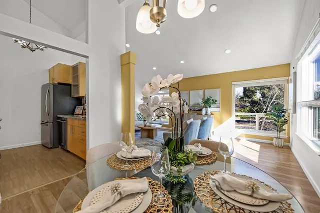 a living room with furniture and a dining table with wooden floor