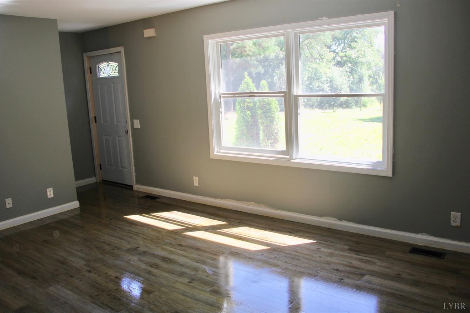 792 Fletchers Level Road Amherst, VA 24521 - Photo 6 of 40 a view of an empty room with wooden floor and a window