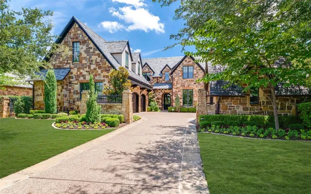 a front view of a house with a yard and trees