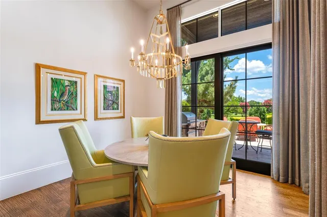 a dining room with furniture a chandelier and wooden floor