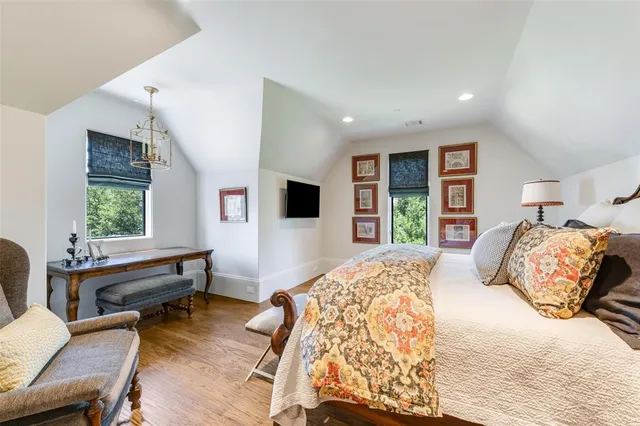 a bedroom with a bed a large window and a flat screen television