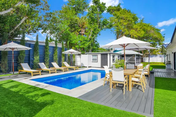 a view of a house with a yard patio and swimming pool
