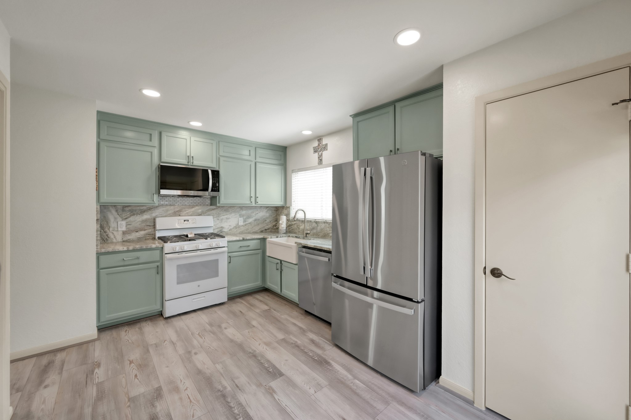 21815 Mossy Field Lane Spring, TX 77388 - Photo 10 of 39 Updated kitchen with painted cabinetry, stainless steel appliances, farmhouse sink, recessed lighting, and modern finishes throughout.