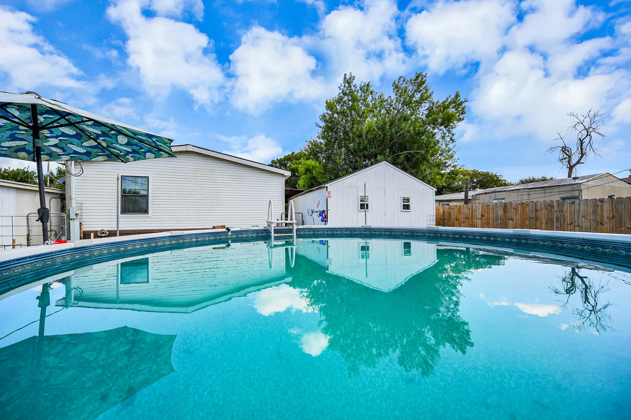 131 Kiowa Court Rosharon, TX 77583 - Photo 33 of 42 A serene backyard featuring an above-ground pool, and a separate storage shed. The area is fenced for privacy. Perfect for outdoor relaxation and entertainment.