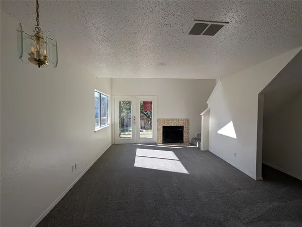 a view of an empty room with a fireplace and a window