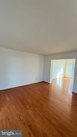 a kitchen with stainless steel appliances granite countertop a refrigerator a stove a sink a dining table and chairs with wooden floor