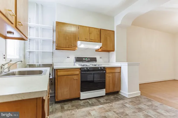 a kitchen with a stove top oven sink and cabinets