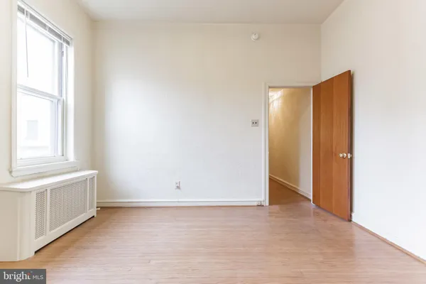 an empty room with windows and closet