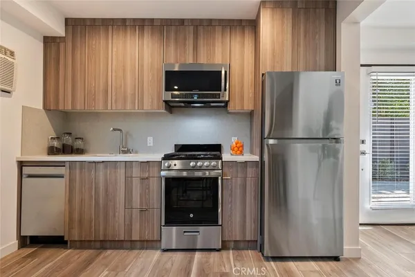 a kitchen with a refrigerator and a stove top oven