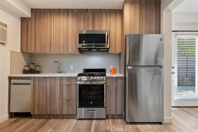 a kitchen with a refrigerator and a stove top oven