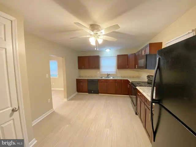 a kitchen with stainless steel appliances granite countertop a refrigerator a oven a sink with a dining table and chairs