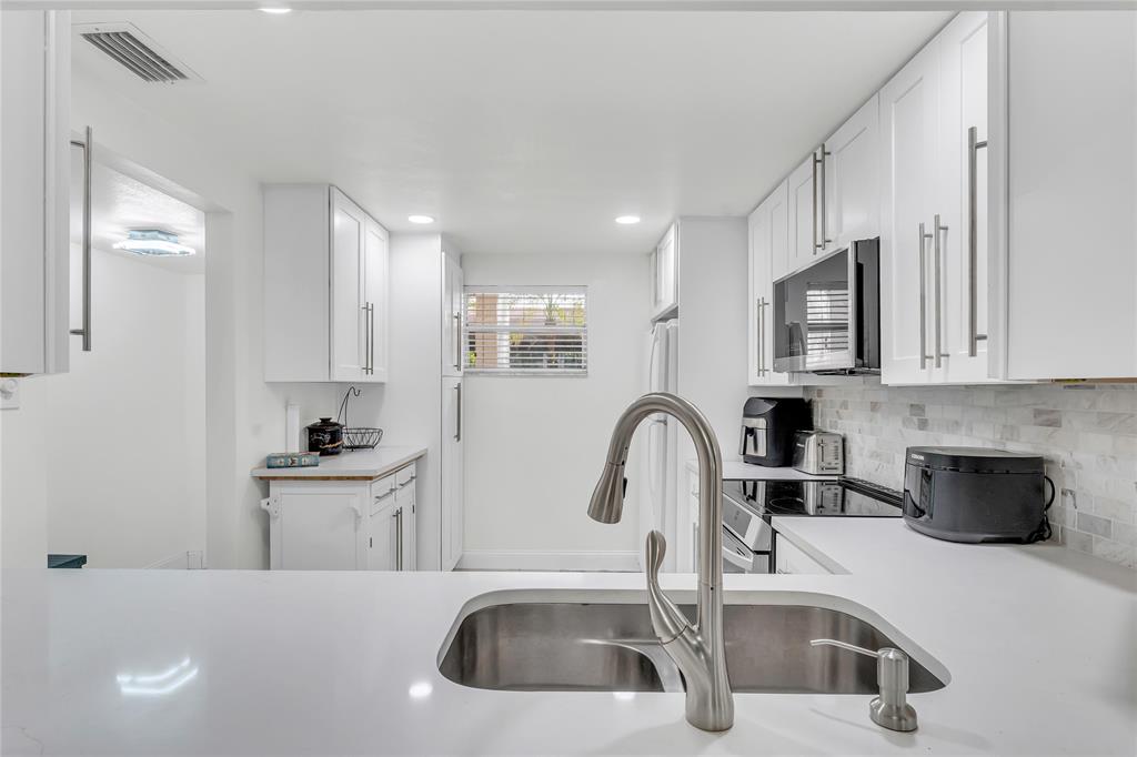 3920 Inverrary Boulevard, Unit 104C Lauderhill, FL 33319 - Photo 2 of 15 a kitchen with stainless steel appliances a sink a stove and cabinets