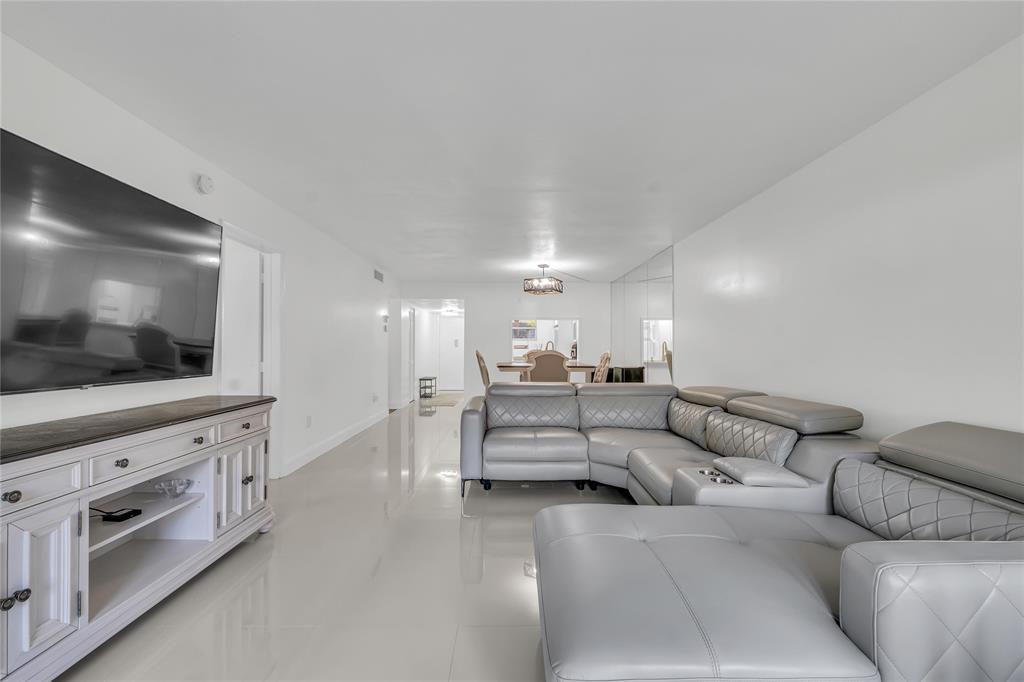 3920 Inverrary Boulevard, Unit 104C Lauderhill, FL 33319 - Photo 5 of 15 a living room with furniture and a flat screen tv