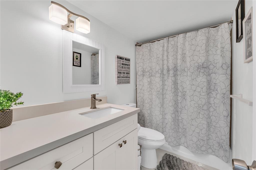 3920 Inverrary Boulevard, Unit 104C Lauderhill, FL 33319 - Photo 8 of 15 a bathroom with a sink a toilet and a mirror