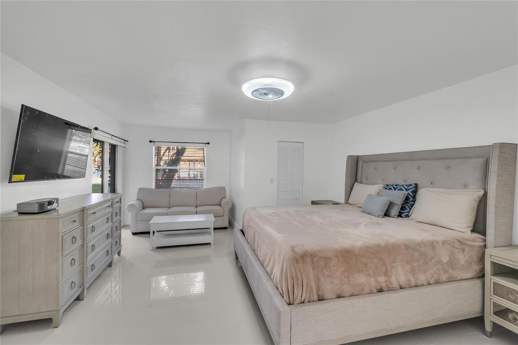 3920 Inverrary Boulevard, Unit 104C Lauderhill, FL 33319 - Photo 9 of 15 a bedroom with a large bed and a flat screen tv
