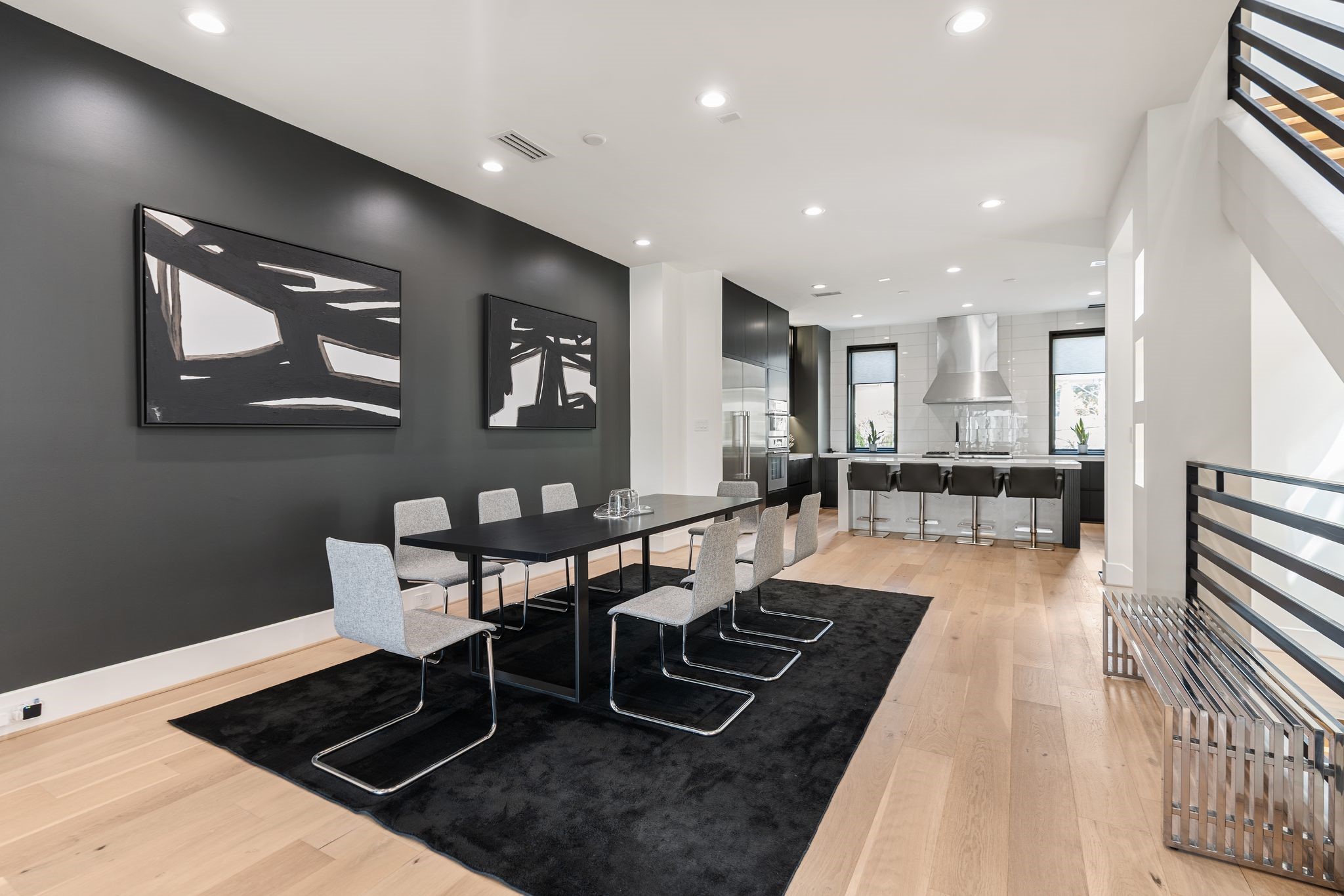 1918 Brun Street Houston, TX 77019 - Photo 19 of 43 Another perspective of the dining area highlights the generous space for hosting and the seamless flow into the designer kitchen. Modern finishes, wide plank wood flooring, and a striking accent wall create a refined atmosphere. There is plenty of room for a large table and chairs for many guests!