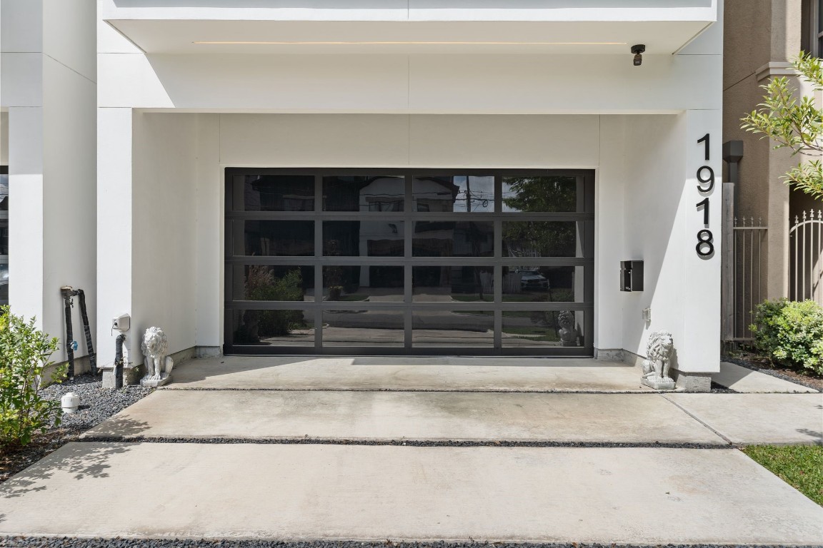 1918 Brun Street Houston, TX 77019 - Photo 2 of 43 A sleek modern façade sets the tone for this impressive residence, featuring a contemporary glass paneled two car garage door, clean architectural lines, and a covered entry drive that enhances the curb appeal.