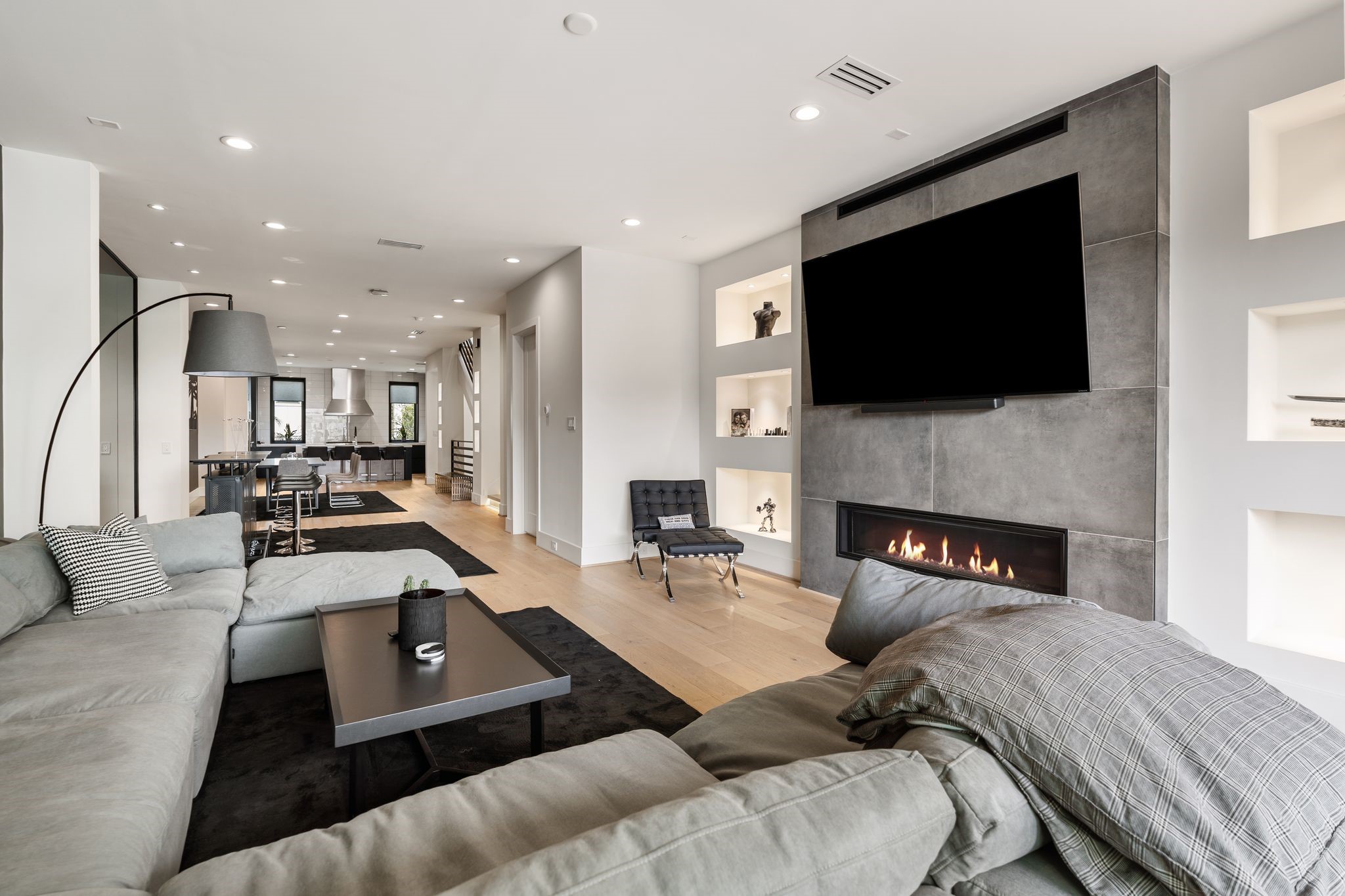 1918 Brun Street Houston, TX 77019 - Photo 25 of 43 A sleek modern fireplace with a striking floor to ceiling surround serves as a stunning focal point in the living room. Built in display niches with accent lighting enhance the architectural appeal as well!