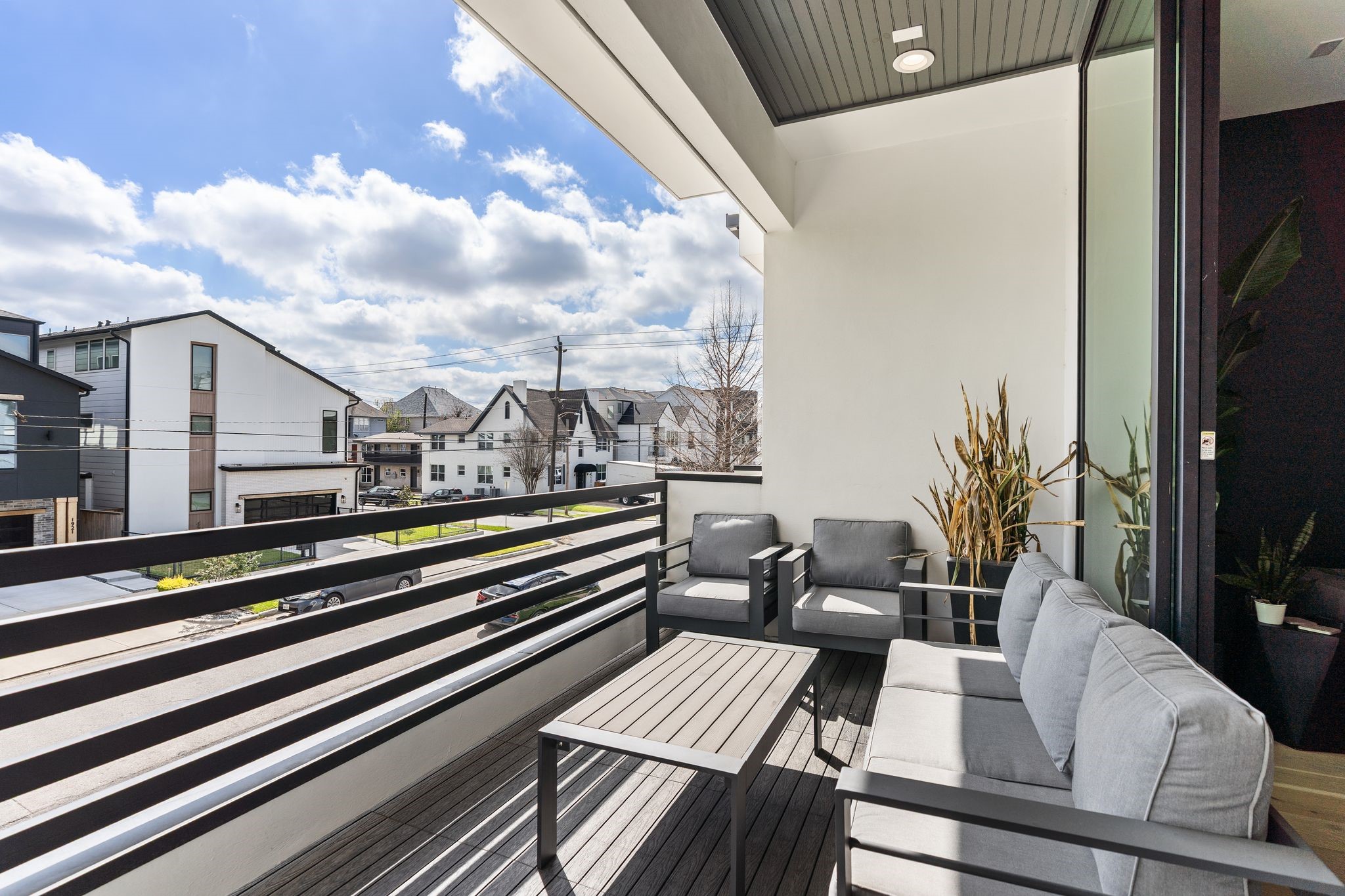 1918 Brun Street Houston, TX 77019 - Photo 26 of 43 Enjoy outdoor living on this private covered balcony, offering the perfect space to relax with morning coffee or unwind in the evening. There is ample room for comfortable seating, while modern horizontal railing design and elevated neighborhood views enhance the contemporary appeal.