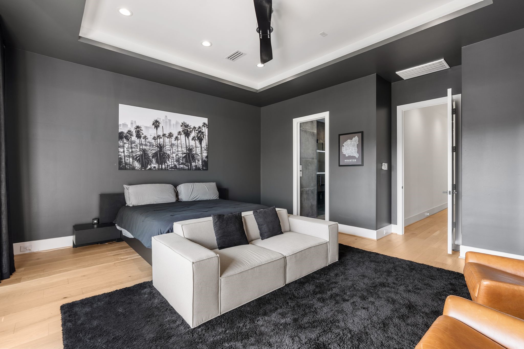 1918 Brun Street Houston, TX 77019 - Photo 30 of 43 Features include a tray ceiling with recessed lighting, sleek ceiling fan, wood flooring, and ample space for a sitting area or additional furnishings.
