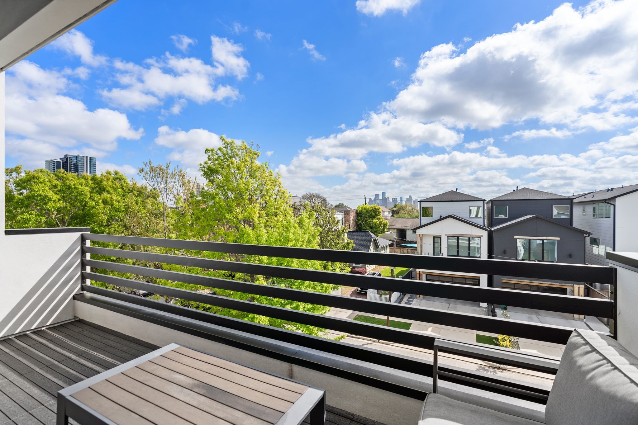 1918 Brun Street Houston, TX 77019 - Photo 33 of 43 Durable decking, modern horizontal railing, and a covered ceiling, and downtown Houston views create a seamless extension of the indoor living space.