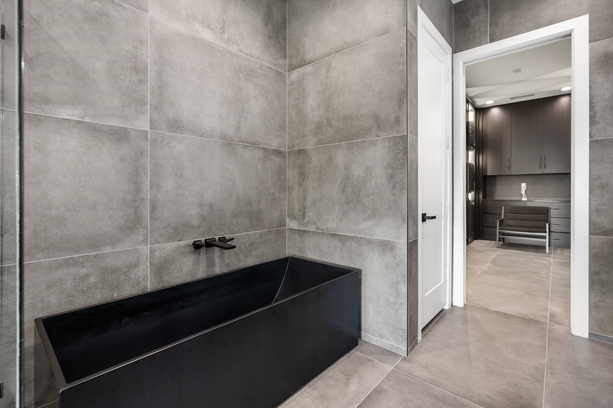 1918 Brun Street Houston, TX 77019 - Photo 35 of 43 Unwind in the striking freestanding soaking tub, perfectly positioned within a dramatic floor to ceiling tiled surround.