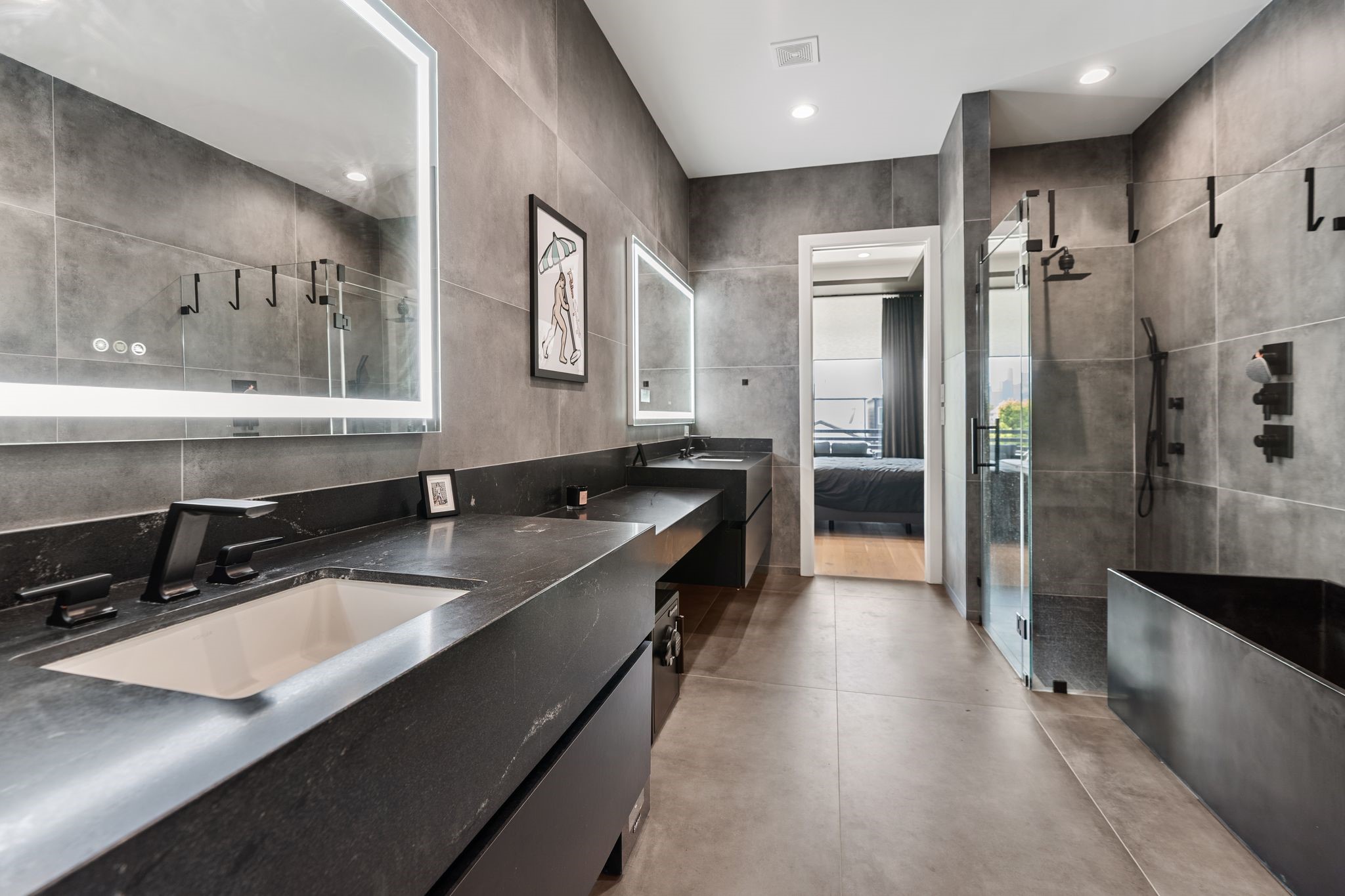 1918 Brun Street Houston, TX 77019 - Photo 37 of 43 Oversized tile surrounds the room, creating a clean and sophisticated feel, while the glass enclosed walk in shower and soaking tub offer a relaxing retreat. Thoughtful lighting and contemporary finishes complete this luxurious space.
