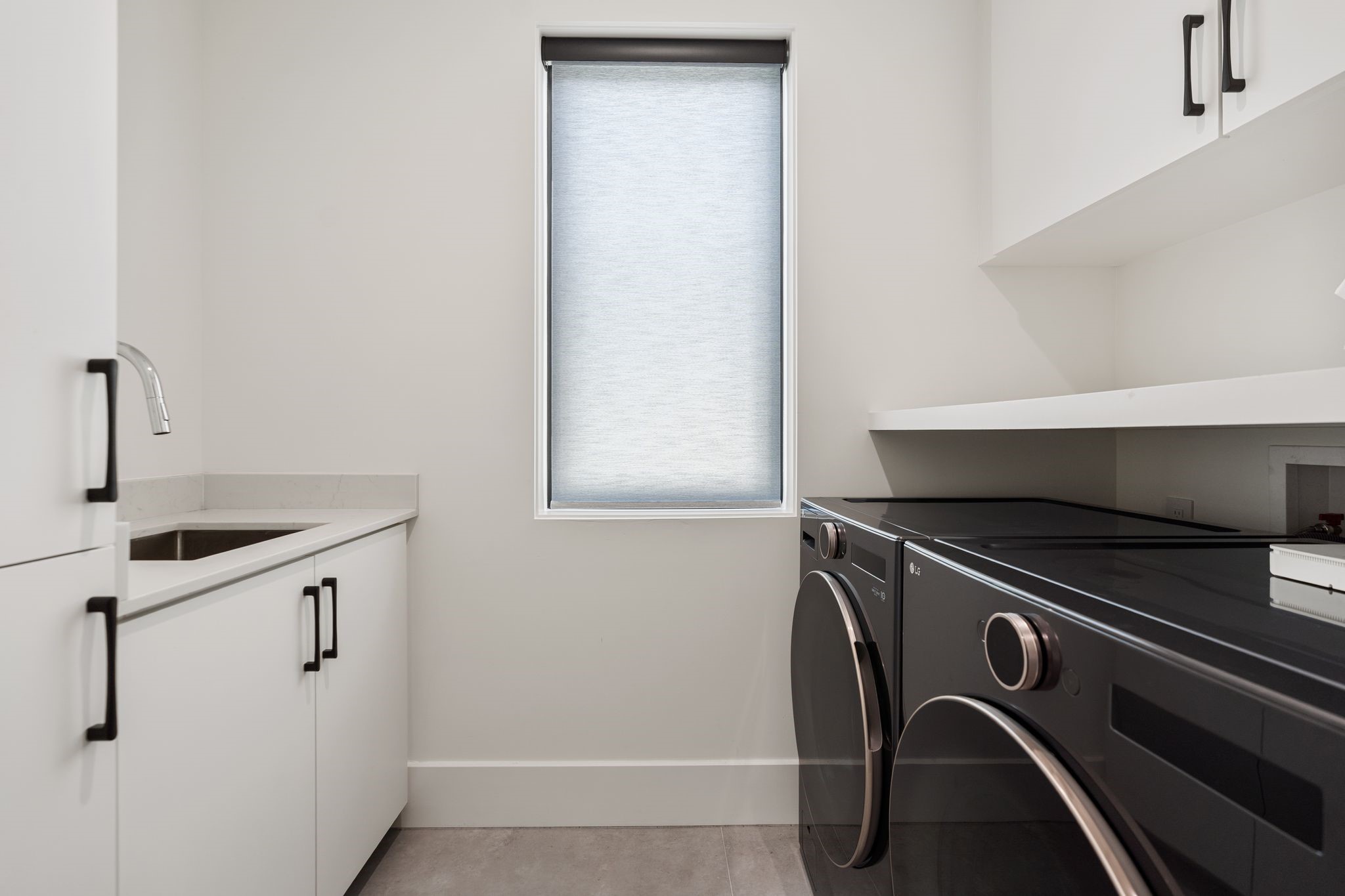 1918 Brun Street Houston, TX 77019 - Photo 39 of 43 This well designed utility room features sleek cabinetry, solid surface countertops, and a convenient sink for everyday tasks. A window provides natural light while upper storage and folding space add practicality.