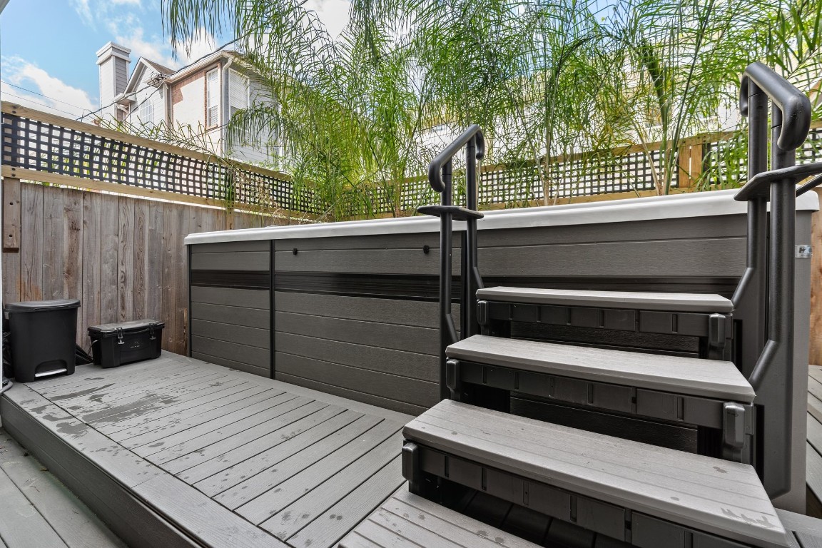 1918 Brun Street Houston, TX 77019 - Photo 7 of 43 Enjoy a private outdoor retreat featuring an elevated deck and a relaxing hot tub, perfect for unwinding or entertaining guests. Privacy fencing and surrounding greenery create a comfortable and inviting outdoor living space.