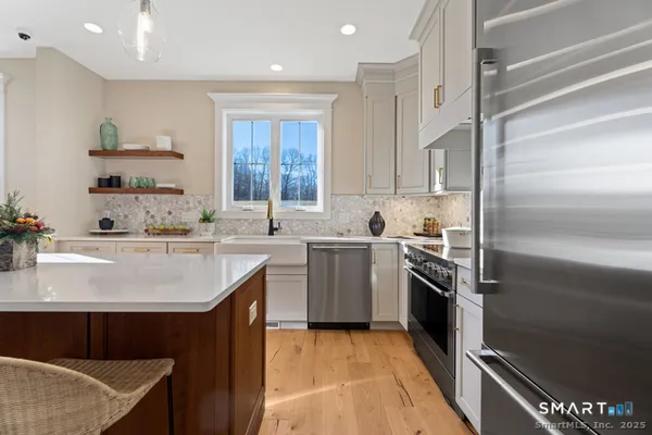 a kitchen with kitchen island granite countertop a sink stove and refrigerator