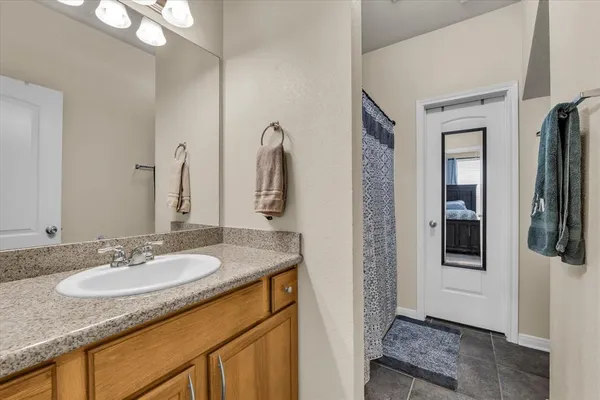 a bathroom with a granite countertop sink and a mirror