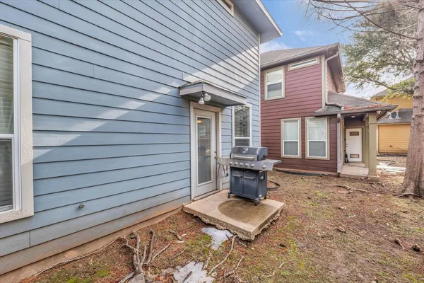 a view of a backyard with chairs and floor to ceiling window and wooden fence