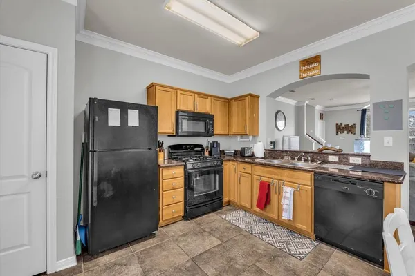 a kitchen with stainless steel appliances granite countertop a stove top oven a refrigerator and a sink