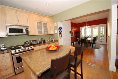 Remodeled kitchen has granite counters and stainless appliances, and opens to dining area.