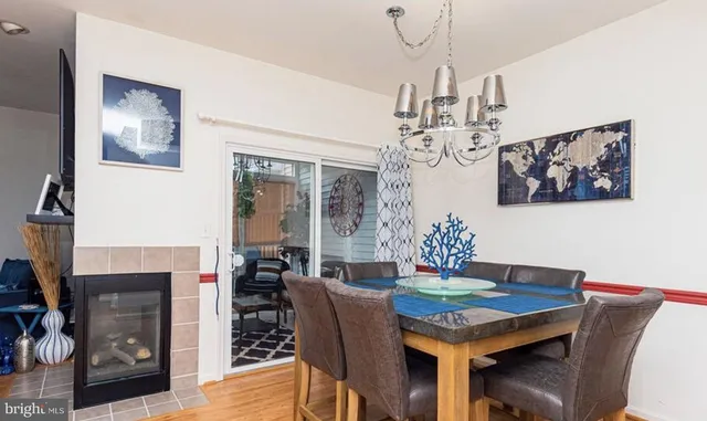 a dining room with furniture a chandelier and wooden floor