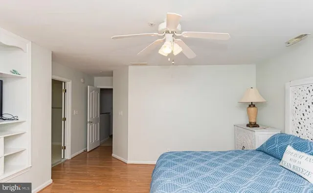 a bedroom with a bed and a lamp on the dresser