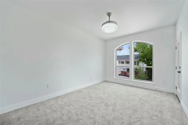a view of a hallway with a chandelier fan