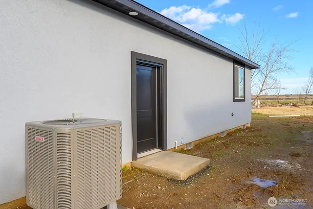 a bedroom with a bed and dresser with wooden floor