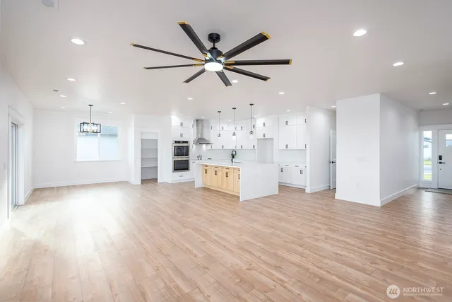 a view of a livingroom with a ceiling fan a ceiling fan and kitchen view