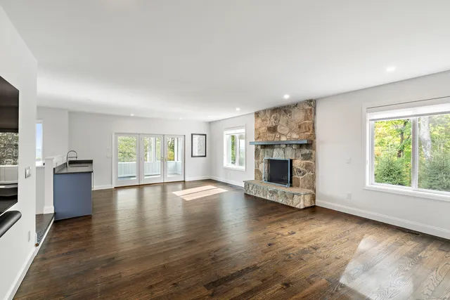 a view of an empty room with a window and fireplace