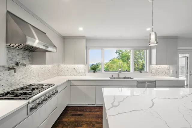 a large white kitchen with a stove top oven