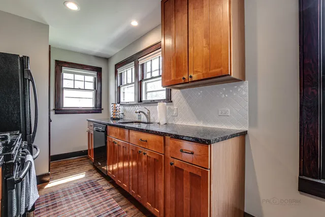 a kitchen with stainless steel appliances granite countertop a sink and a refrigerator