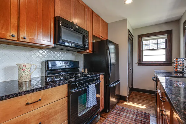 a kitchen with stainless steel appliances granite countertop a stove microwave and refrigerator