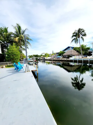 a view of a lake with a table and chairs under an umbrella