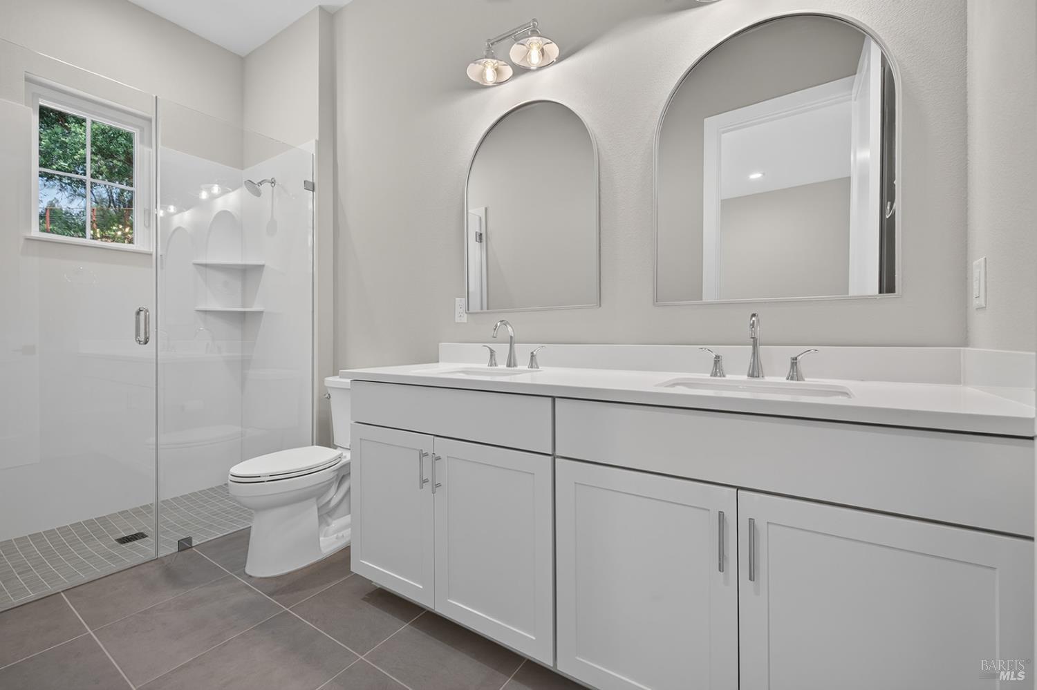1907 Carlile Place Santa Rosa, CA 95403 - Photo 23 of 55 Main level primary suite offers this beautiful bathroom with a curb less stall shower (for easy access), tiled flooring, tiled walls in the shower and dual sink vanity with quartz countertop.